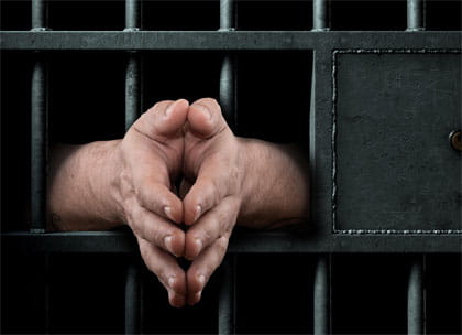Hands in prison bars